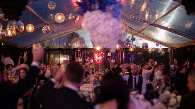 Disco balls, sepia-toned florals with pops of colour, neon lights and a custom bar completed the couple’s special day. Picture: Luke John Photography