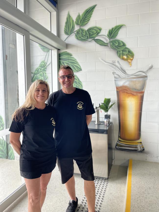 Goanna Brewing owners Kerri Donnelly and Aneurin ‘Nye’ Williamsnext to a hops and beer mural by Gwada Murals' Martin Jegou at the new venue at 2c Victoria St in 2024. Photo: Zoe Devenport