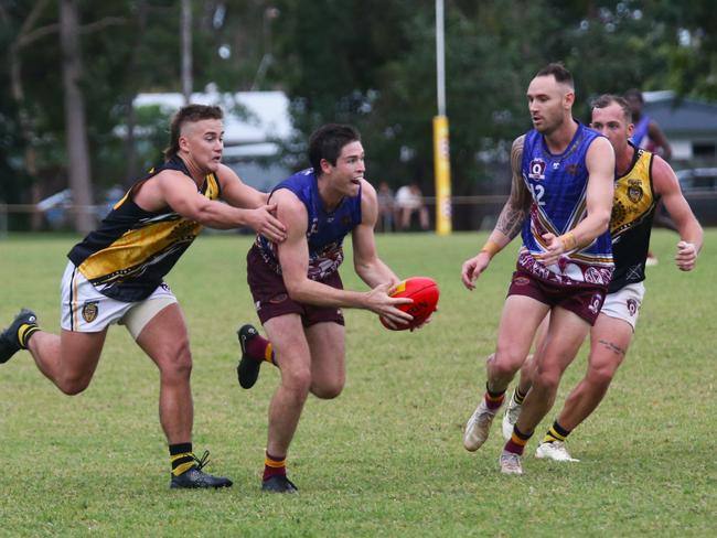 Pictured: Lion Daniel Charlesworth tackled by Jonah George. Cairns City Lions v North Cairns Tigers at Holloways Beach. Dreamtime by the Sea. AFL Cairns 2024. Photo: Gyan-Reece Rocha