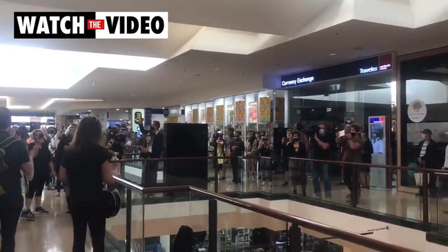 Anti-lockdown protesters sing John Farnham classic at shopping centre