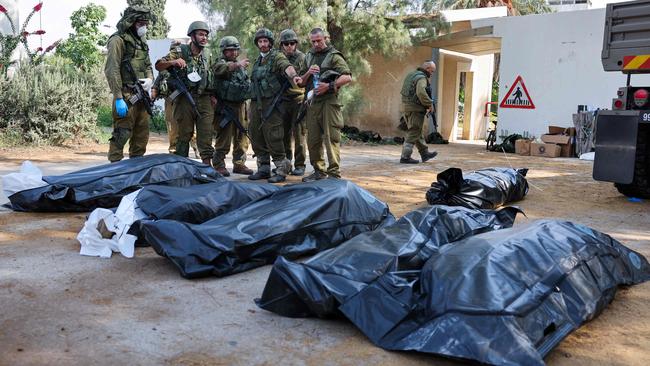 Israeli soldiers prepare to remove the bodies of those killed in Kfar Aza, south of Israel bordering Gaza Strip.