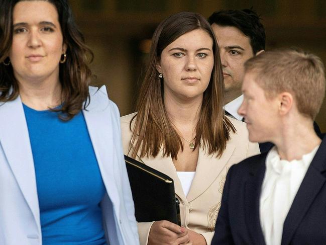 Brittany Higgins (C) leaves the ACT Magistrates Court in Canberra on October 5, 2022. - Brittany Higgins, a former government aide allegedly sexually assaulted inside Australia's federal parliament, gave her first direct testimony on October 5 to the high-profile rape trial. (Photo by AFP)