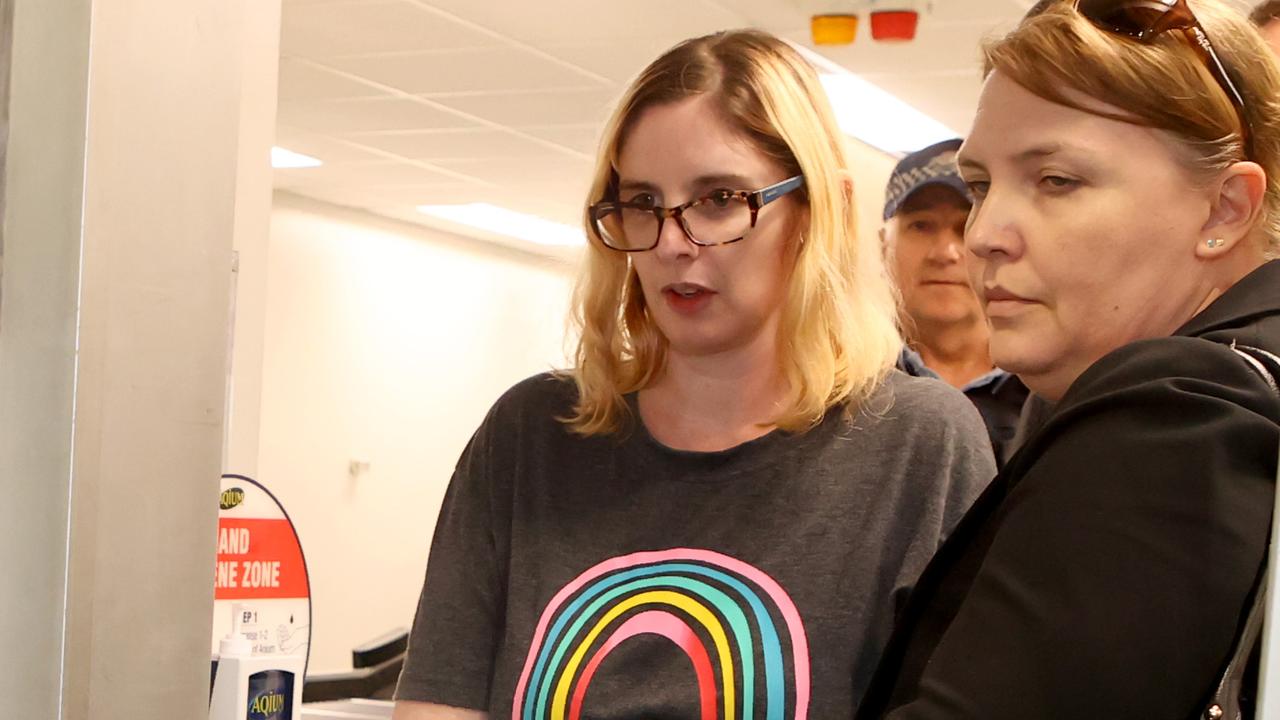 Lisa Lines (wearing a T-shirt) is escorted by police after being extradited back to Australia. Picture: NewsWire / Kelly Barnes