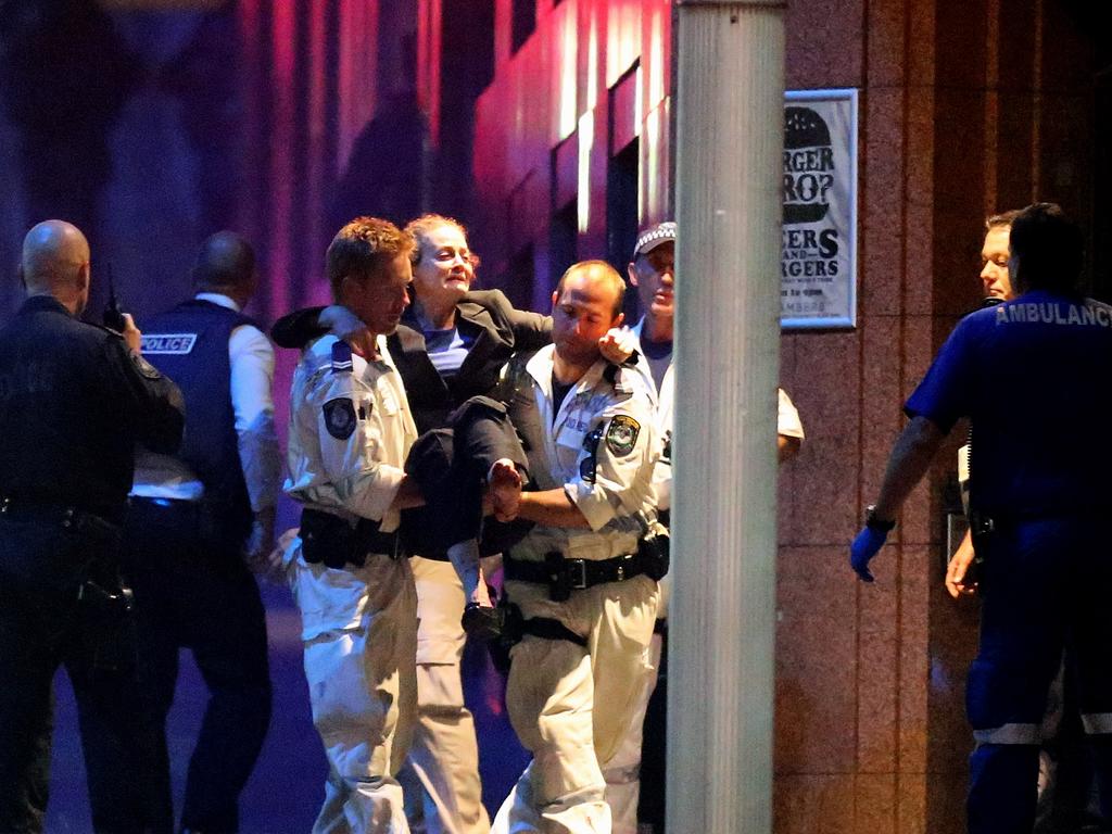 Afemale hostage is carried out after police stormed the Sydney cafe. Picture: Getty Images