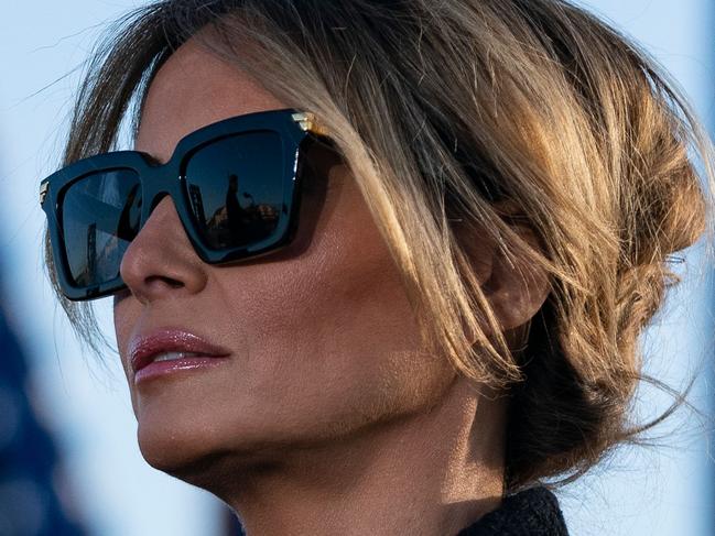 Outgoing First Lady Melania Trump listens as her husband Outgoing US President Donald Trump addresses guests at Joint Base Andrews in Maryland on January 20, 2021. - President Trump and the First Lady travel to their Mar-a-Lago golf club residence in Palm Beach, Florida, and will not attend the inauguration for President-elect Joe Biden. (Photo by ALEX EDELMAN / AFP)