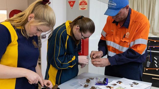 Roma State College students assembling prosthetic hands. Photo: Origin Energy / Contributed