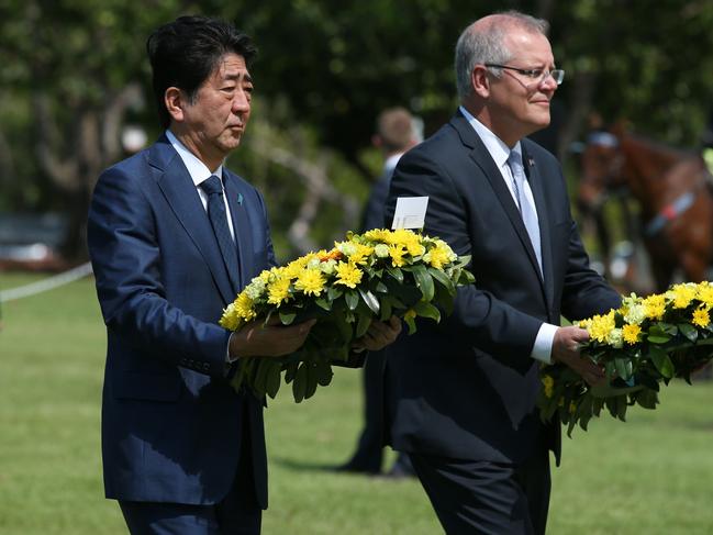 Japan's Prime Minister Shinzo Abe (L) walks with Australia's Prime Minister Scott Morrison during a wreath laying ceremony at the Darwin Cenotaph in Darwin on November 16, 2018. - Abe made a historic visit to Darwin on November 16, some 75 years after Japan bombed the northern Australian city, as the two countries cement ties in the face of emergent China. (Photo by DAVID MOIR / AFP)