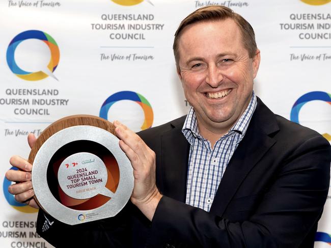 Ry Collins holding the Top Small Tourism Town gold prize.