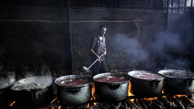 A man in Rafah cooks for Palestinians displaced by the war. Picture: AFP