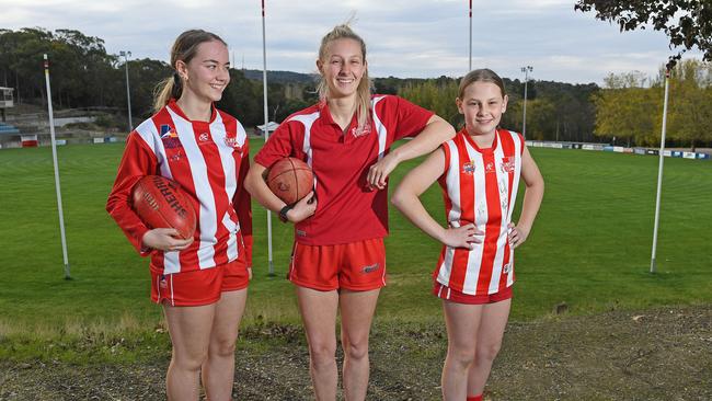 Mount Lofty A grade women’s players Maddy Taylor (jumper) and Holly Aiston (polo) with under-14 rising star Keira May, can't wait to get back to playing footy. Picture: Tom Huntley