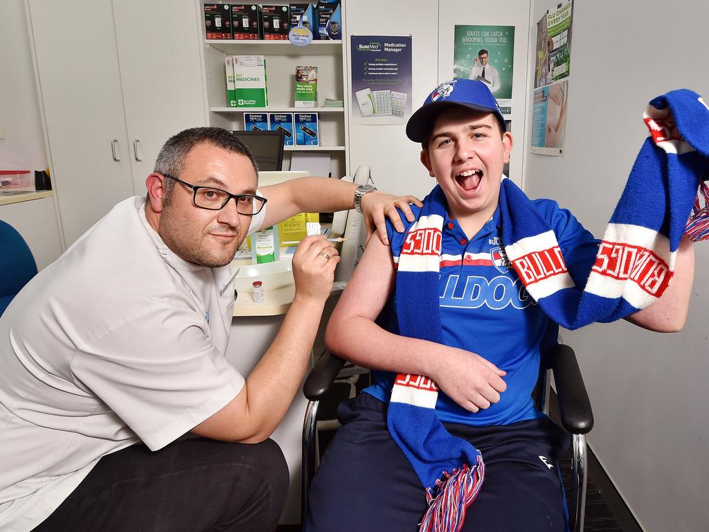 Fourteen year-old Bulldogs fan Marcos Barbaressos, getting the Covid jab by Pharmacist Anthony Tassone, at Terry White Chemmart, Clyde. Picture: Nicki Connolly