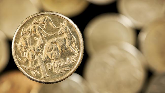 Australian one dollar coin over blurred golden background.