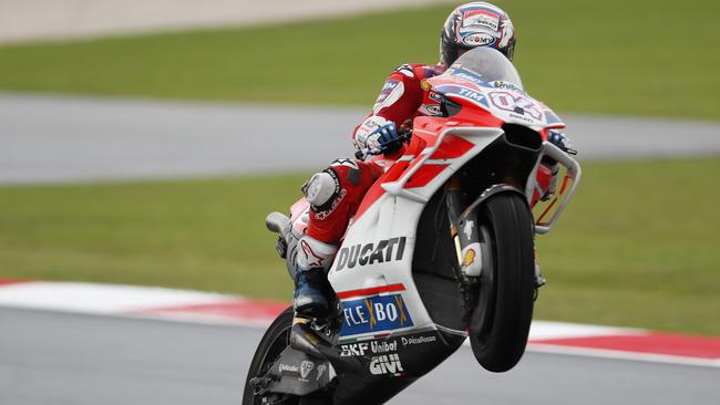 Italy's MotoGP rider Andrea Dovizioso does a wheelie with his Ducati during the second practice session of the Malaysia MotoGP at the Sepang International circuit in Sepang, Malaysia, Friday, Oct. 27, 2017. (AP Photo/Vincent Thian)