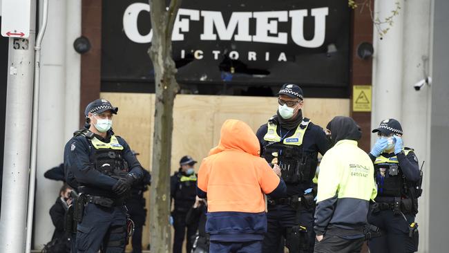 Police question tradies outside the CFMEU offices in Melbourne on Tuesday. Picture: Andrew Henshaw