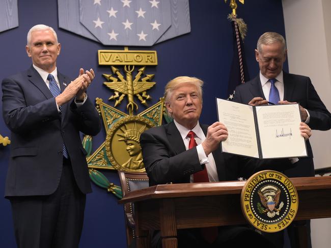 US President Donald Trump shows his signature on executive orders alongside US Defense Secretary James Mattis and US Vice President Mike Pence. Picture: AFP