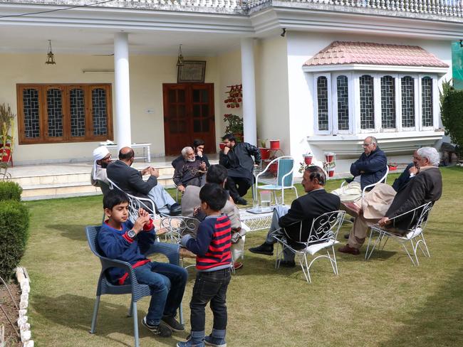 Relatives of Naeem Rashid gather in a garden to express their condolences at his home. Picture: AFP