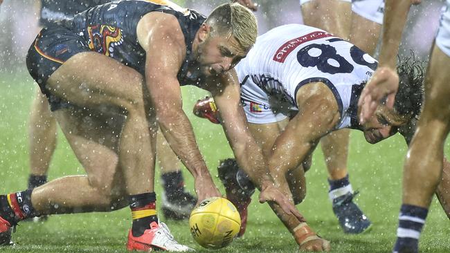 Rory Atkins of the Crows battles Docker Brady Grey in the rain at Adelaide Oval. Picture: David Mariuz (AAP)
