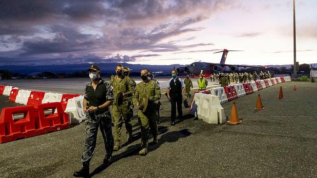 Australian Defence Force Attaché to the Solomon Islands, Commander Mark Northcote, RAN, directs personnel from Joint Task Group 637.3 at Honiara airport on November 26, 2021.