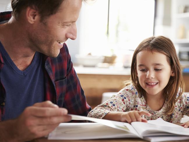 Father home schooling his young daughter