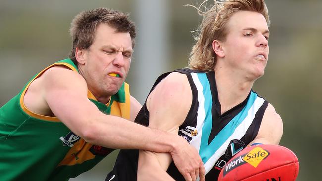 Wonthaggi’s Jack Hutchinson tries to get a handball away under pressure from Leongatha’s Sean Westaway. Picture Yuri Kouzmin