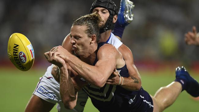 Nat Fyfe gets a handball away under pressure from Caleb Daniel.