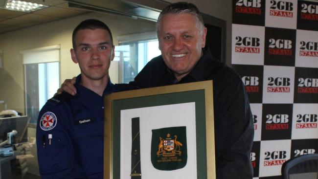 Ray Hadley presents paramedic Dalton Lynch with his grandfather’s Kangaroos tie.