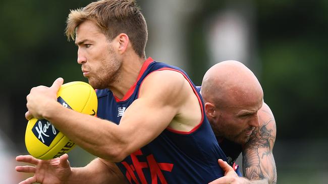 Jack Viney pushes through a tackle from Nathan Jones at Melbourne training.