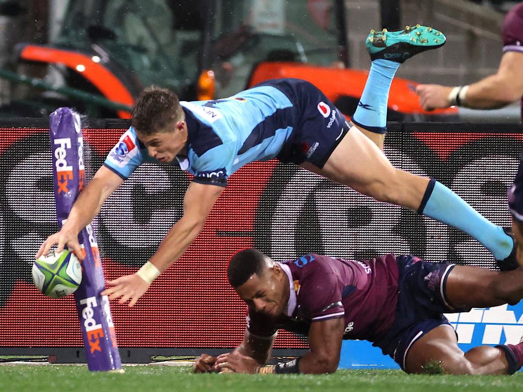 Waratah Alex Newsome divers over Reds winger Filipo Daugunu at the SCG. Picture: David Gray / AFP