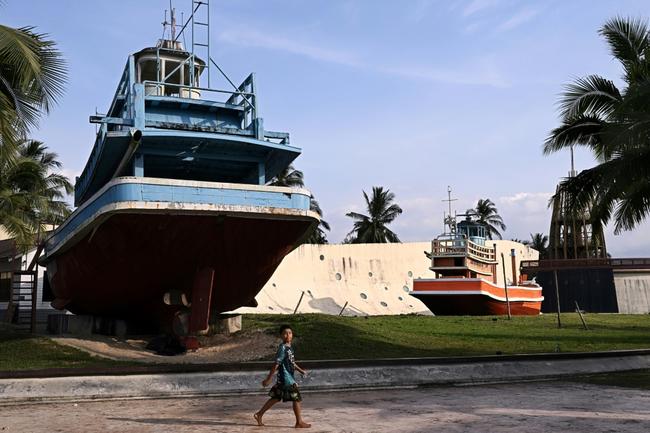 A boy walks past the Ban Nam Khem Tsunami Museum in the southern Thai province of Phang Nga