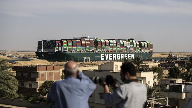 People watch as the container ship 'Ever Given' is refloated, unblocking the Suez Canal.