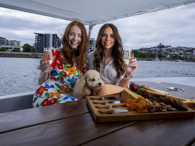 Tess Alexander and Tara Carroll enjoy a picnic on the Brisbane River aboard a GoBoat. Picture: Jerad Williams