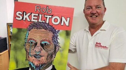 Nicklin MP Rob Skelton poses with graffitied sign.