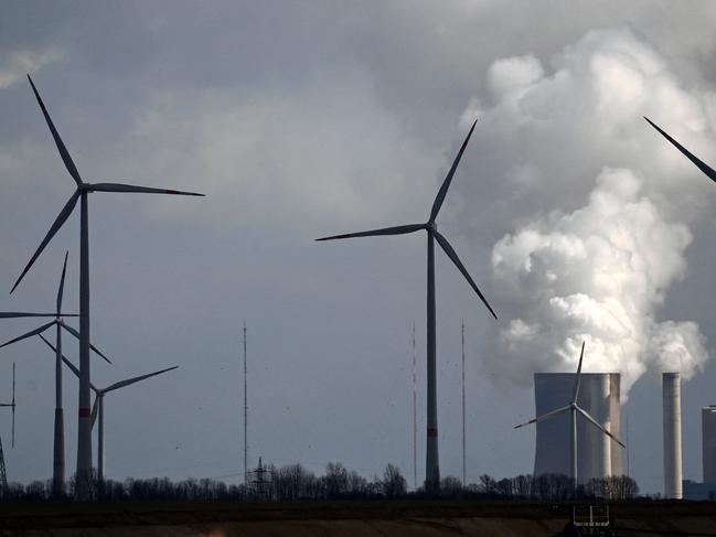 Wind turbines are seen near the coal-fired power station Neurath of German energy giant RWE in Garzweiler, western Germany, on March 15, 2021. - On March 16, 2021, the group will present its detailed figures for 2020, for the last time with RWE CEO Rolf Martin Schmitz. Despite the coronavirus pandemic, 2020 was a successful year for RWE. (Photo by Ina FASSBENDER / AFP)