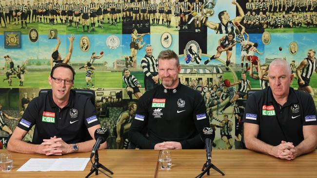 Collingwood coach Nathan Buckley, centre, announces his tenure at the club is over