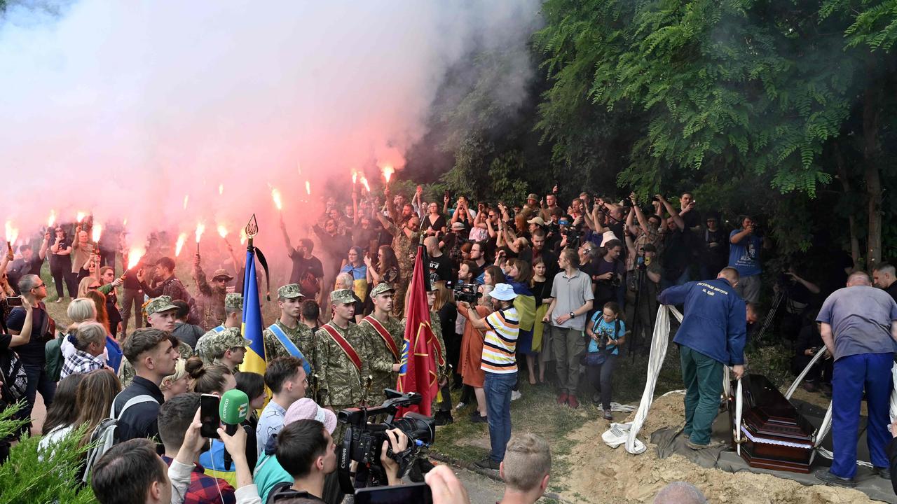 Activists and friends light flares during the funeral ceremony of killed Ukrainian serviceman Roman Ratushny at a cemetery in Kyiv on June 18, 2022, amid the Russian invasion of Ukraine. Picture: Genya Savilov / AFP