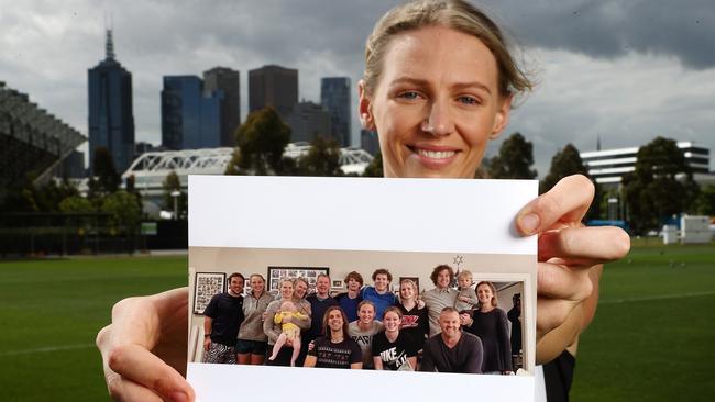 Collingwood AFLW player Imogen Purcell with a photo of her family, including nine siblings. Picture: Michael Klein