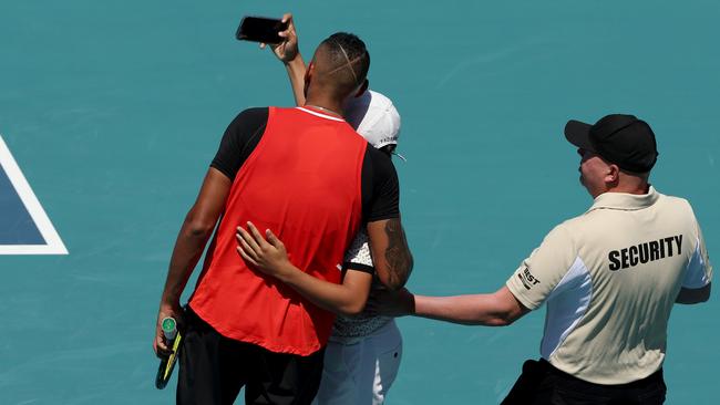 A spectator runs on court and takes a selfie with Nick Kyrgios during the Miami Open clash with Jannick Sinner. Photo: Getty Images