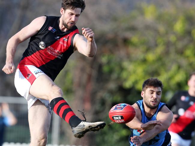 West Adelaide’s Stuart Taverner gets his kick away under pressure from Sturt’s James Battersby. Picture: Sarah Reed