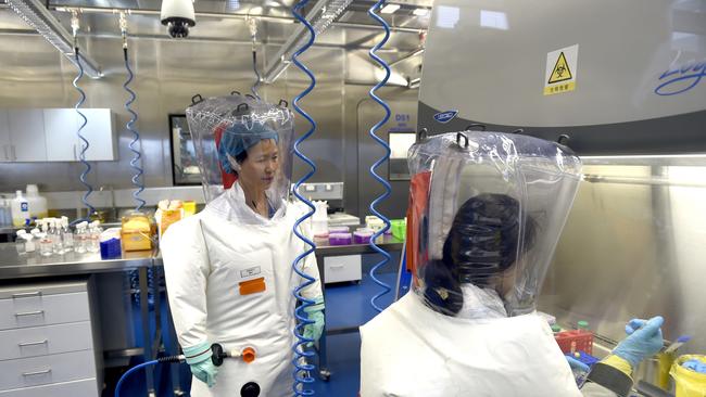 Virologist Shi Zheng-li, left, works with her colleague in the P4 lab of Wuhan Institute of Virology in 2017.