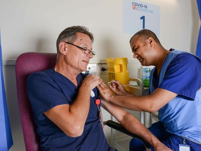 Registered nurse Subash Chapagai gives Queen Elizabeth Hospital Emergency Dept Nursing Unit Manager Chris McCaskill the AstraZeneca vaccine. Picture: NCA NewsWire / Brenton Edwards