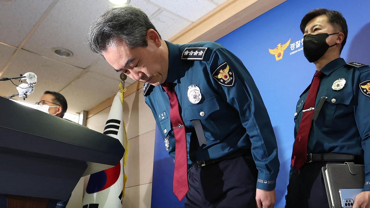 South Korea's National Police Agency Commissioner Yoon Hee-keun (C) bows during a press conference on the deadly Halloween crowd surge. (Photo by YONHAP / AFP)