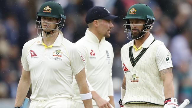 Australia's Steve Smith, left, and teammate Matthew Wade walk off the pitch as rain stops play on day three. Picture: AP