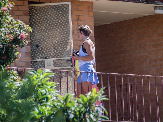 A woman opens the security door to the second-story apartment last month. Picture: Jason Edwards