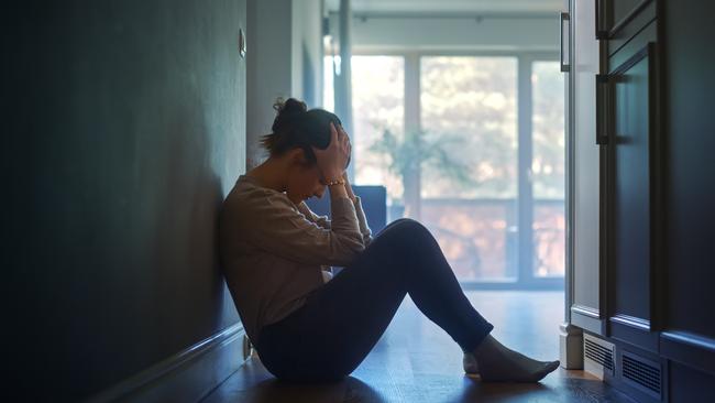 istock generic:  woman, abuse, DV, domestic violence, harassment, sexual harassment.   Sad Young Woman Sitting on the Floor In the Hallway of Her Appartment, Covering Face with Hands. Atmosphere of Depression, Trouble in Relationship, Death in the Family. Dramatic Bad News Moment . Picture: istock