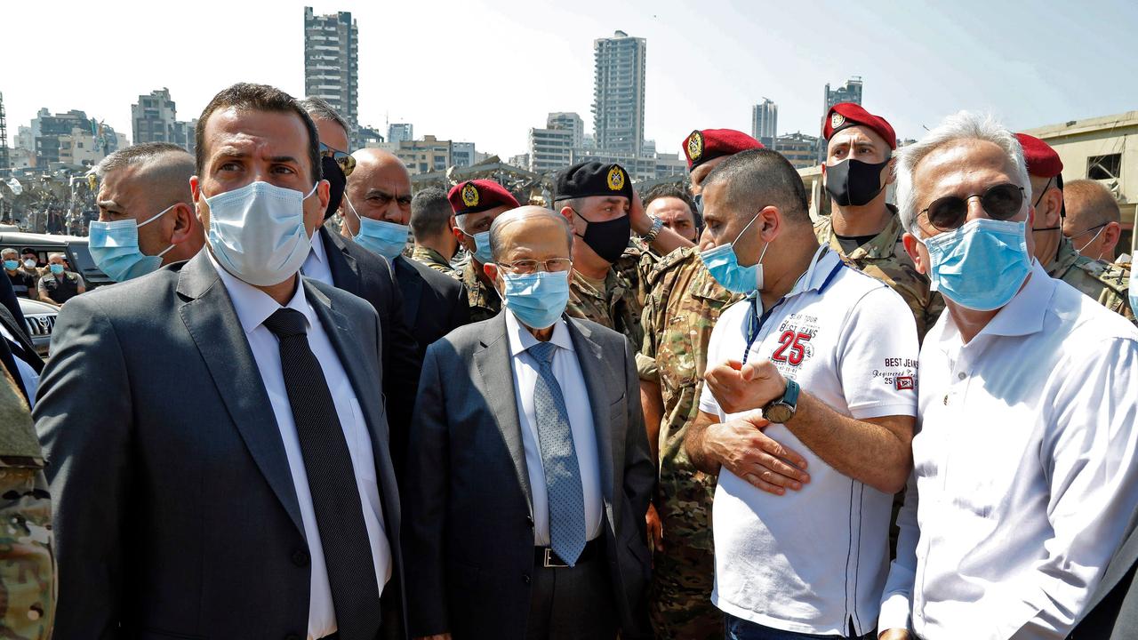 Lebanon's President Michel Aoun, centre, wears a protective face mask as he visits the site. Picture: AFP