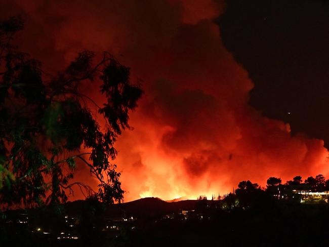 Smoke and flames from the Palisades fire burn toward the Encino neighbourhood of Los Angeles, triggering new evacuation orders. Picture: AFP