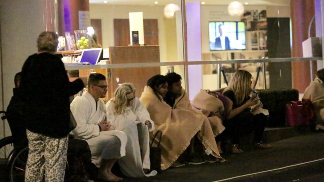 Novotel hotel guests huddle in the cold after being evacuated.