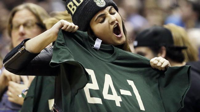 A fan cheers while holding up a "24-1" shirt during the second half.