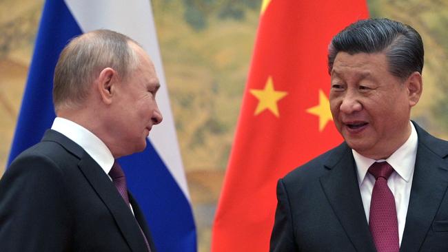 Russian President Vladimir Putin (L) and Chinese President Xi Jinping arrive to pose for a photograph during their meeting in Beijing, on February 4, 2022. (Photo by Alexei Druzhinin / Sputnik / AFP)