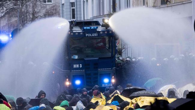 Police use water cannon to remove demonstrators protesting against the Alternative for Germany (AfD) far-right party in Hanover, northern Germany, on early December 2, 2017. The far-right AfD party who captured nearly 13 percent of the vote the September general election, gathers on December 2 and 3 to elect a new leadership, with police bracing for potentially violent street protests against the anti-migrant, anti-Islam party. / AFP PHOTO / dpa / Peter Steffen / Germany OUT